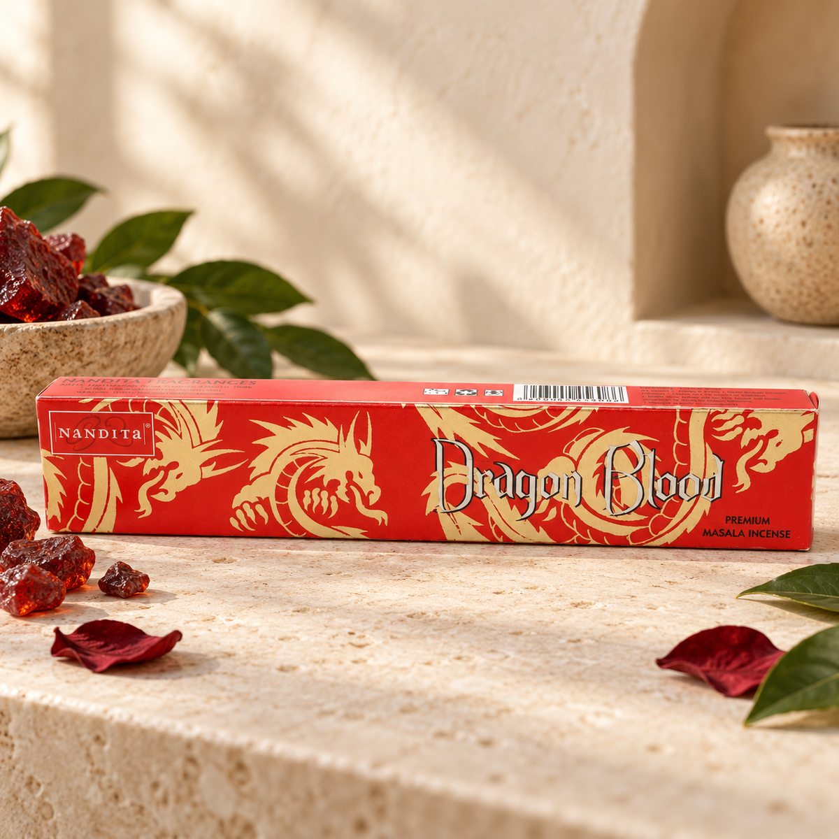 Nandita Dragon Blood 15g incense on a warm ivory stone surface with red resin