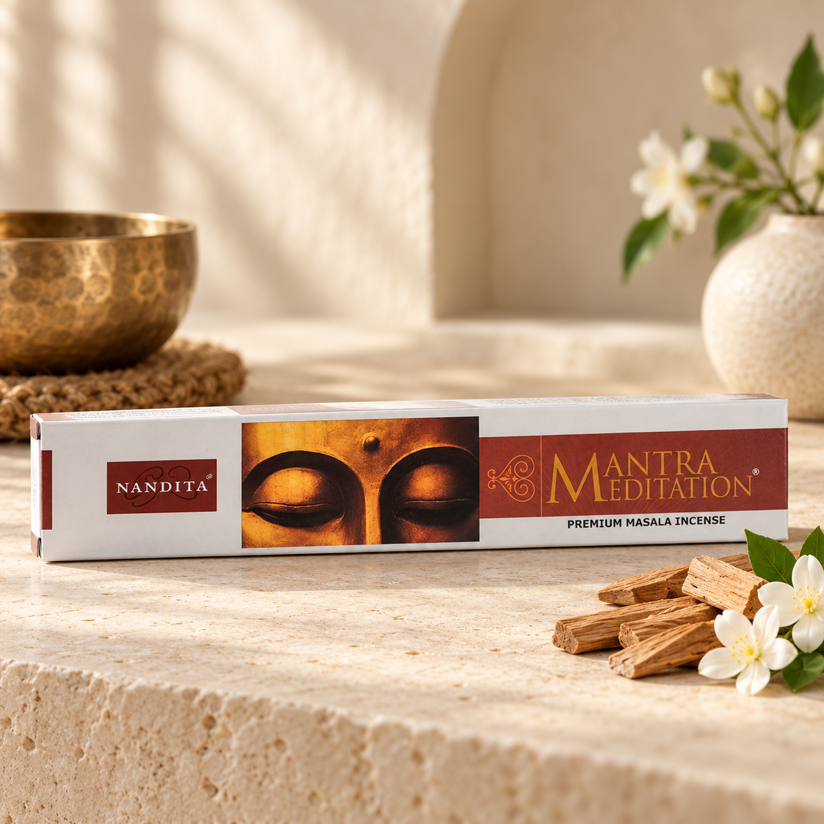 Nandita Mantra Meditation 15g incense on a warm ivory stone surface with sandalwood and blossoms