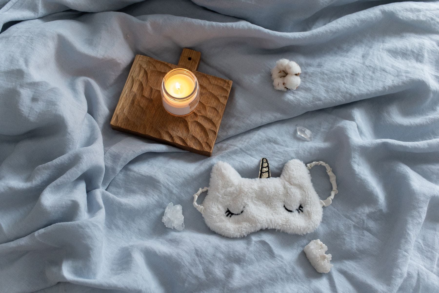 Soft candlelight beside comfortable bedding