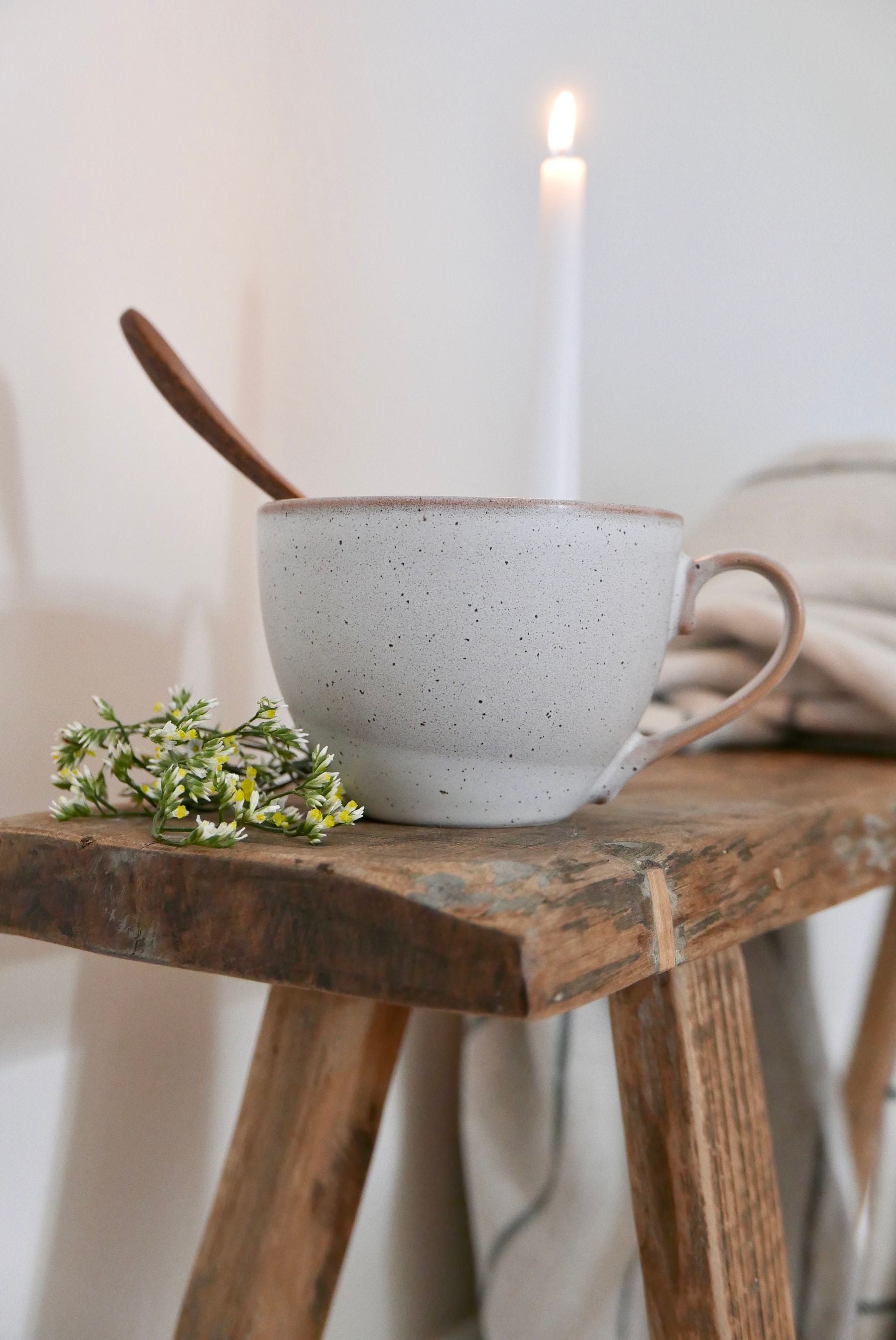 Herbal tea beside a candle and blanket